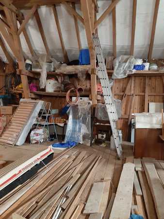 Dachboden mit Holzlatten, Bauholz, Werkzeugen und Baumaterial für Renovierungsarbeiten.